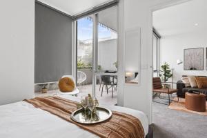 a bedroom with a bed and a living room at Ultimate Comfort Gem in St Kilda in Melbourne