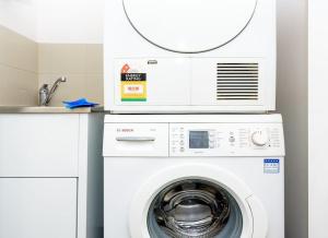 a washer and dryer in a kitchen with a mirror at Ultimate Comfort Gem in St Kilda in Melbourne
