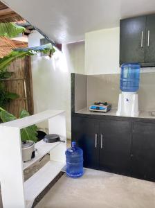 une cuisine avec un comptoir avec des récipients bleus dessus dans l'établissement Casa Luna 3 by Angelito's, à General Luna