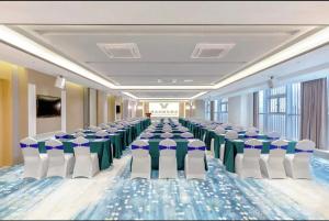 sala konferencyjna z rzędami krzeseł i stołów w obiekcie Vienna International Hotel Shenzhen Baolong subway Station branch w mieście Longgang