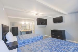 a hotel room with two beds and a television at Sands Inn by OYO Winnie in Winnie