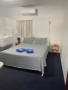 Un dormitorio con una cama con toallas azules. en Injune Motel, en Injune
