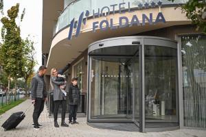 un groupe de personnes debout à l'extérieur d'un bâtiment dans l'établissement Hotel Foldana, à Budapest