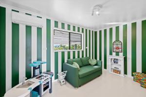 sala de estar con paredes de rayas verdes y blancas en Spearmint House - Art Deco Gem in Misty Mountains, en Berner Creek