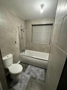 a bathroom with a toilet and a bath tub at Luxary private detached property in Brettell Lane