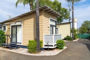 una pequeña casa amarilla con una palmera en Injune Motel, en Injune