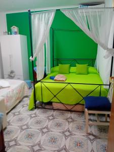 Dormitorio verde con cama y pared verde en Beach house en Mondello