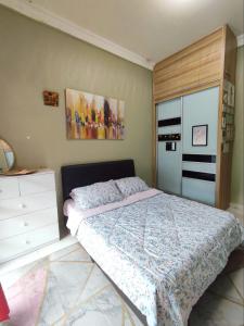Un dormitorio con una cama y una cómoda. en Bukit Villa, en Brinchang