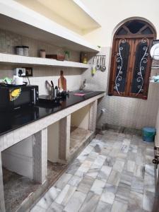 a kitchen with a black counter top in a room at Shiva INN in Varanasi