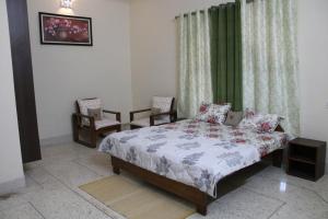 a bedroom with a bed and two chairs at Shiva INN in Varanasi