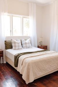 1 dormitorio con cama con almohadas y ventana en Pet Friendly Family Home in Bluff Point en Geraldton