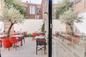 a view of a patio with tables and chairs through a window at Hotel Italia in Zelzate