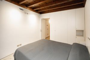 a bedroom with white cabinets and a gray bed at Casa del Sarto in Mantova