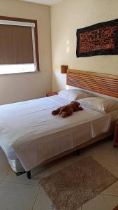 um cão deitado numa cama num quarto em Apartamento condomínio Vila la Torre em Porto Seguro