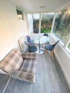 uma sala de estar com um sofá, uma mesa e cadeiras em Gravesend 2 Bedroom Spacious Stylish Apartment - Sleeps upto 6 - 2 Min Walk to Station em Kent