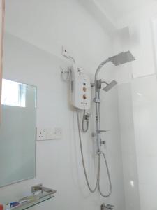 a shower in a bathroom with a shower head at Friendly house in Galle