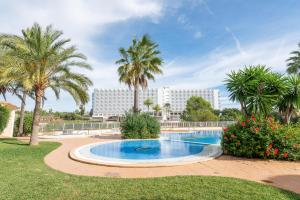 uma piscina com palmeiras e um edifício em Es Mirador - Cales de Mallorca em Calas de Mallorca
