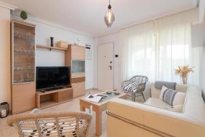 uma sala de estar com um sofá e uma televisão em Es Mirador - Cales de Mallorca em Calas de Mallorca