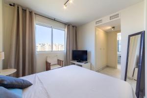 um quarto com uma grande cama branca e uma televisão em Agua Serena em Roquetas de Mar