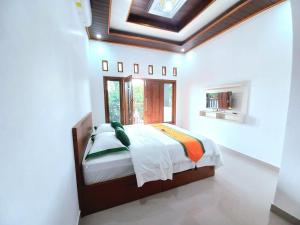 um quarto com uma cama num quarto com um tecto em Homestay Jogja Prambanan By Simply Homy em Sleman