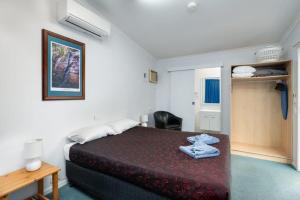 Habitación de hotel con cama, escritorio y habitación en Injune Motel, en Injune