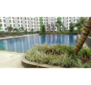 a building with a palm tree and a swimming pool at OYO Life 93374 Andira Inn in Depok
