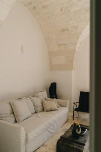 - un canapé blanc dans le salon avec plafond dans l'établissement Palazzo Bergamotti, à Ostuni