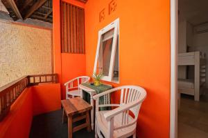 an orange room with a table and two chairs at The Room Padang-Padang in Uluwatu