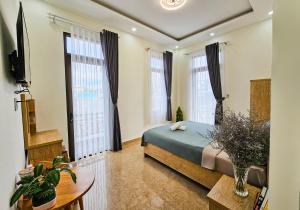 a bedroom with a bed and two large windows at Mai DiaMond Hotel in Da Lat