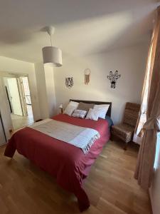 - une chambre avec un grand lit rouge et une chaise dans l'établissement Charmant T3 proche plaine de l’Ain, à Saint-Jean-de Niost