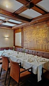 施韋因福特的住宿－羅斯酒店，用餐室配有带白色桌布的桌子