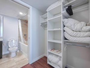 a bathroom with a toilet and a stack of towels at 1BDR&Bath&Den I AC I 600sq.ft I Free WiFi&Parking in Richmond