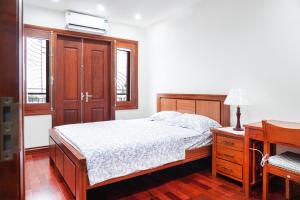 1 dormitorio con 1 cama, vestidor y escritorio en Splendor Trendy Aparment en Hanoi