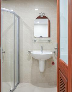 uma casa de banho com um lavatório, um chuveiro e um espelho. em Splendor Trendy Aparment em Hanói