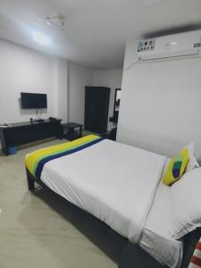 a bedroom with a white bed and a tv at HOTEL AMIGOS in Hyderabad