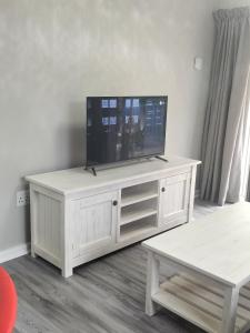 a white entertainment center with a flat screen tv on it at CHARMING GETAWAY in George
