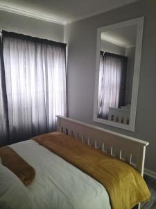 sypialnia z dużym łóżkiem i lustrem w obiekcie CHARMING GETAWAY w mieście George