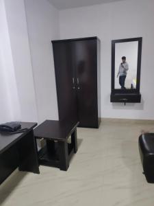 a living room with a table and a black cabinet at HOTEL AMIGOS in Hyderabad