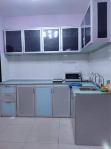 uma cozinha com armários brancos e um lavatório em Daxxlence Swimming Pool Homestay Kinta RiverFront em Ipoh