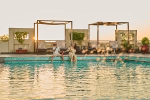 a group of people playing in the water at Flora Airport Hotel and Convention Centre Kochi in Nedumbassery