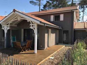 een huis met een houten terras ervoor bij La Cigale du Pyla, au cœur de l'écoquartier avec piscine commune in La Teste-de-Buch