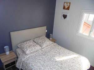 een slaapkamer met een bed en een raam bij La Cigale du Pyla, au cœur de l'écoquartier avec piscine commune in La Teste-de-Buch +24 foto's