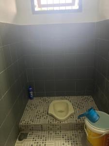 łazienka z toaletą w wyłożonej kafelkami podłodze w obiekcie B&B Family Farmhouse w mieście Cikelet