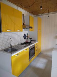 a kitchen with yellow cabinets and a sink at SeaHarbour Pesaro in Pesaro