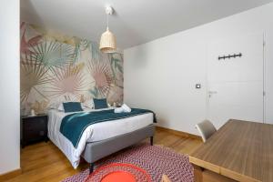 a bedroom with a bed and a table with a rug at MAISON EOLE in Villeurbanne