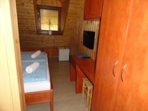 Cette petite chambre comprend un lit et une télévision. dans l'établissement Penzion Žumberk, à Nové Hrady