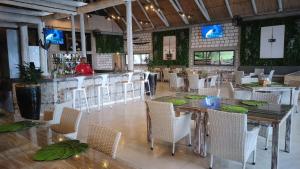 a restaurant with a table and chairs and a bar at Mukumbura Lodge Bilene in Vila Praia Do Bilene