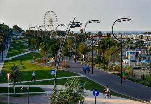 un parco con persone che camminano e ruota panoramica di Hotel Cuba Aeroport Restaurant a Rimini