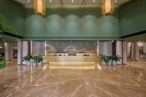 a lobby with potted plants in a building at Flora Airport Hotel and Convention Centre Kochi in Nedumbassery
