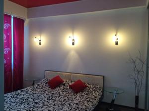 sypialnia z 2 czerwonymi poduszkami na łóżku w obiekcie Decebal Residence w Kiszyniowie